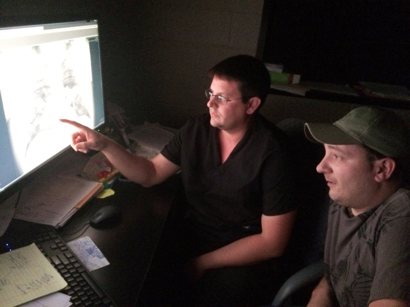 Radiologist Brandon Crum and former coal miner Mackie Branham, 39, view an X-ray of Branham's diseased lung at Crum's black lung clinic in Coal Run Village, Ky. Howard Berkes/NPR